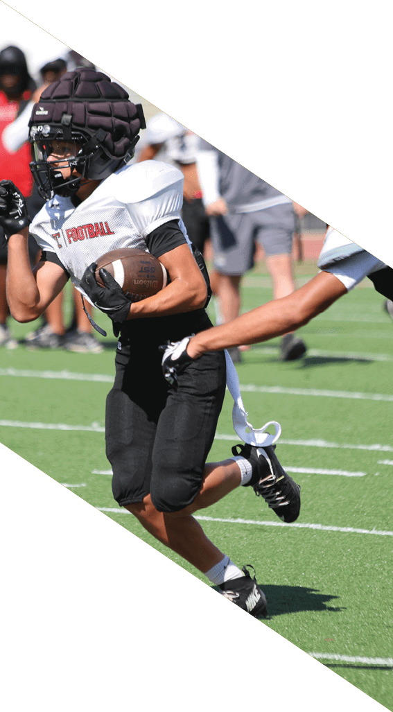 A football player wearing a black helmet and white jersey is holding a football in his hands. AI generated content