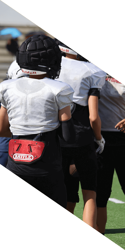 Two men are jumping in the air on a field, both wearing football uniforms. AI generated content