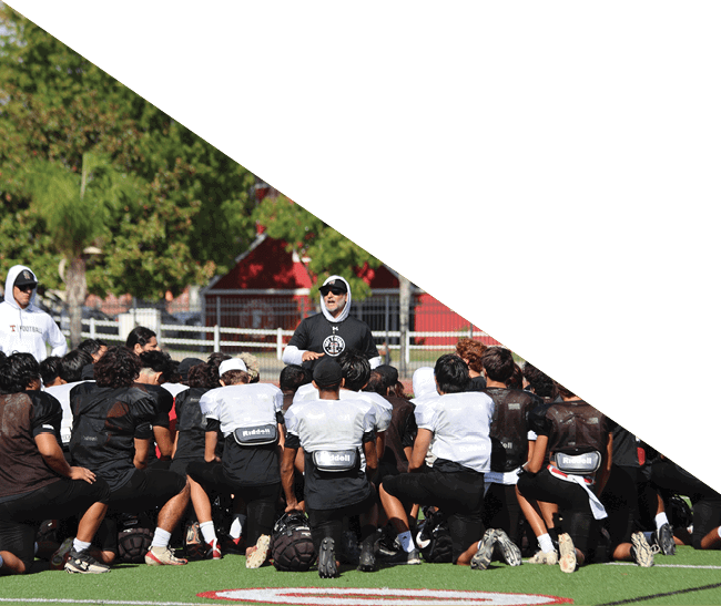 A group of football players kneeling on the field, some with their hands on their heads. AI generated content