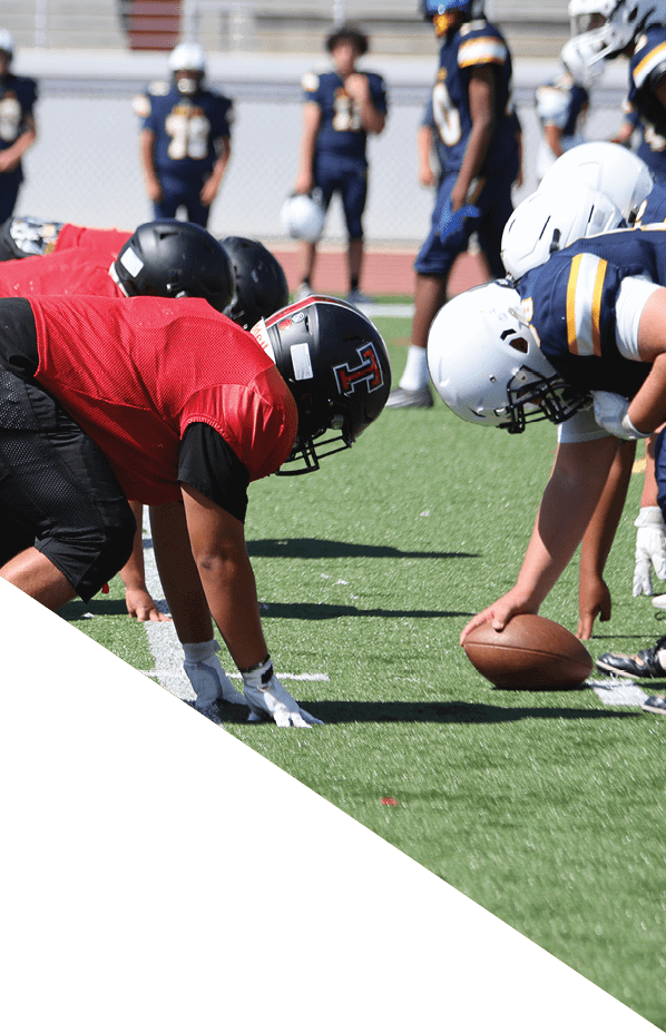 A football player is kneeling on the field, holding his helmet in his hands. AI generated content