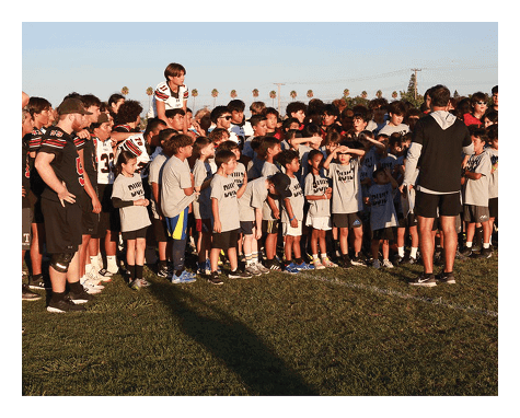 A group of young men wearing black jerseys with the word “Vista" on the front are celebrating a victory. AI generated content