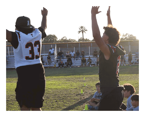A man wearing a football uniform is jumping to catch a football. AI generated content