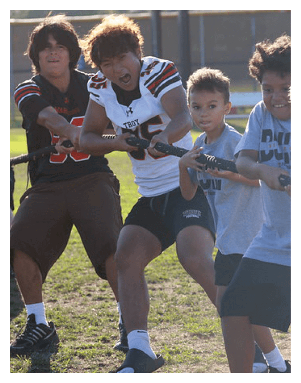 A football player wearing a helmet and white uniform is holding his helmet above his head. AI generated content