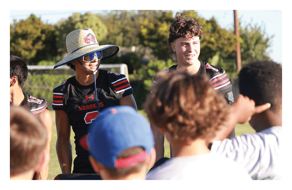 A group of football players wearing headphones and smiling. AI generated content