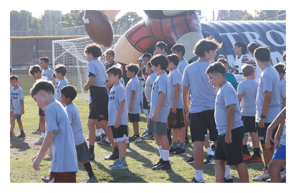 A group of people are kneeling on a field, possibly in a football game. AI generated content