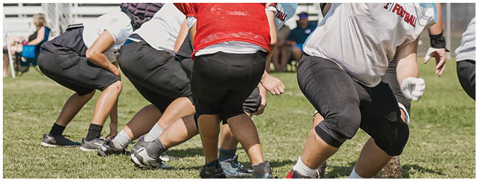 A group of football players on a field. Description generated by AI