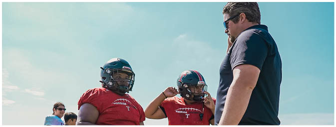 A group of football players on a field. Description generated by AI