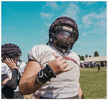 A football game is taking place with a group of men on the field. Description generated by AI