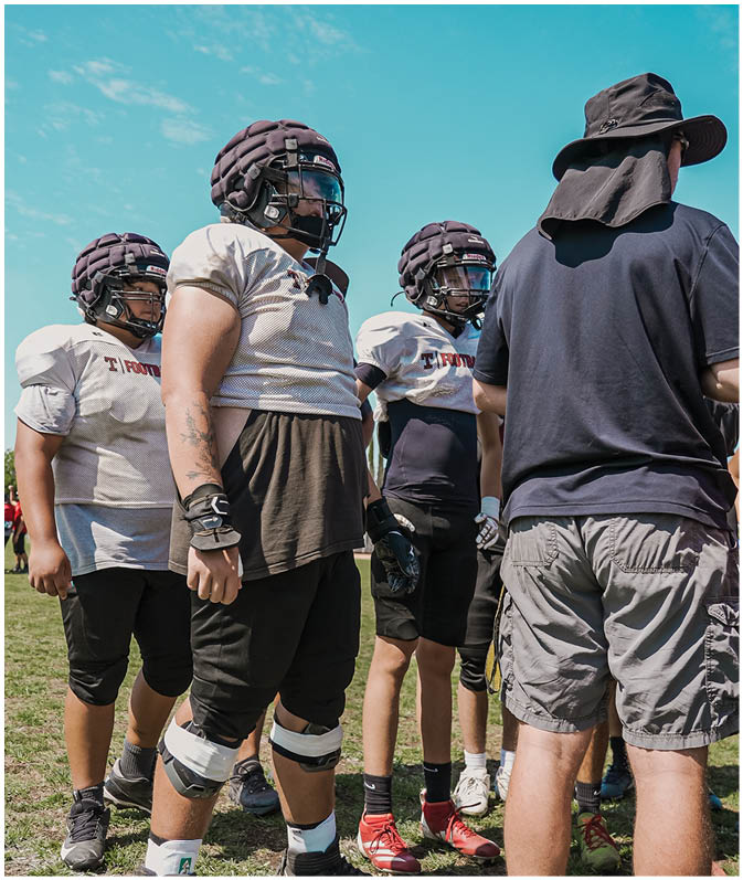 A group of football players on a field. Description generated by AI