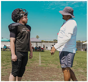 A football game is taking place with a group of men on the field. Description generated by AI
