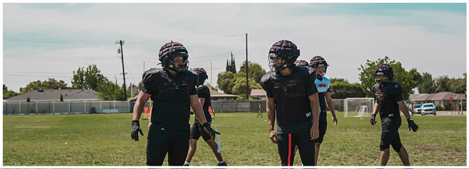 A football game is taking place on a field with players wearing blue and white uniforms. Description generated by AI