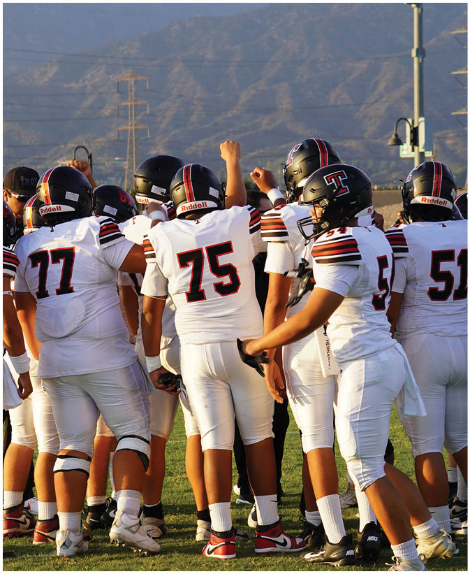 A group of football players on a field. Description generated by AI