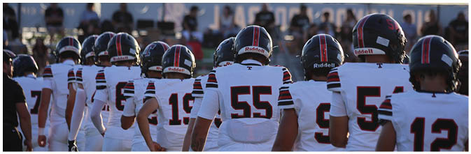 A group of football players on a field. Description generated by AI