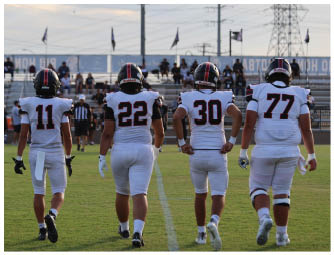A group of football players on a field. Description generated by AI