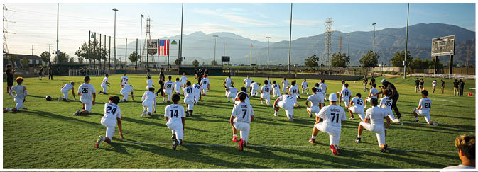 A football game is taking place on a field with players wearing blue and white uniforms. Description generated by AI