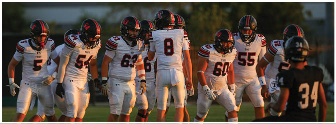 A football game is taking place on a field with players wearing blue and white uniforms. Description generated by AI