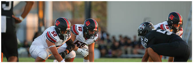 A group of football players on a field. Description generated by AI