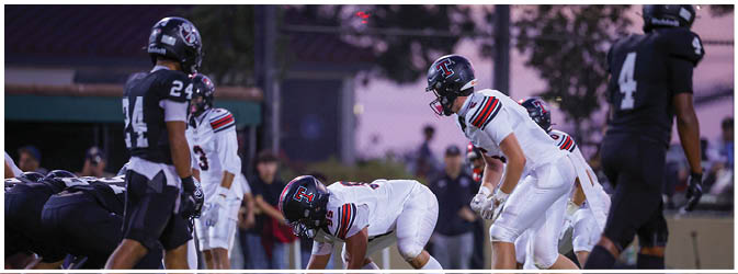 A football game is taking place on a field with players wearing blue and white uniforms. Description generated by AI