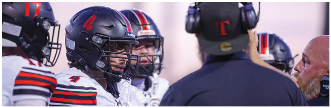 A group of football players on a field. Description generated by AI
