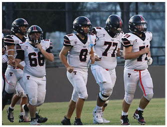 A group of football players on a field. Description generated by AI