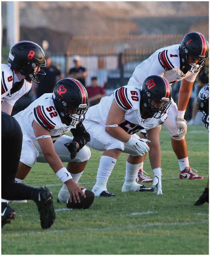 A group of football players on a field. Description generated by AI