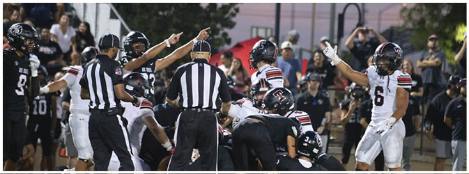 A football game is taking place on a field with players wearing blue and white uniforms. Description generated by AI