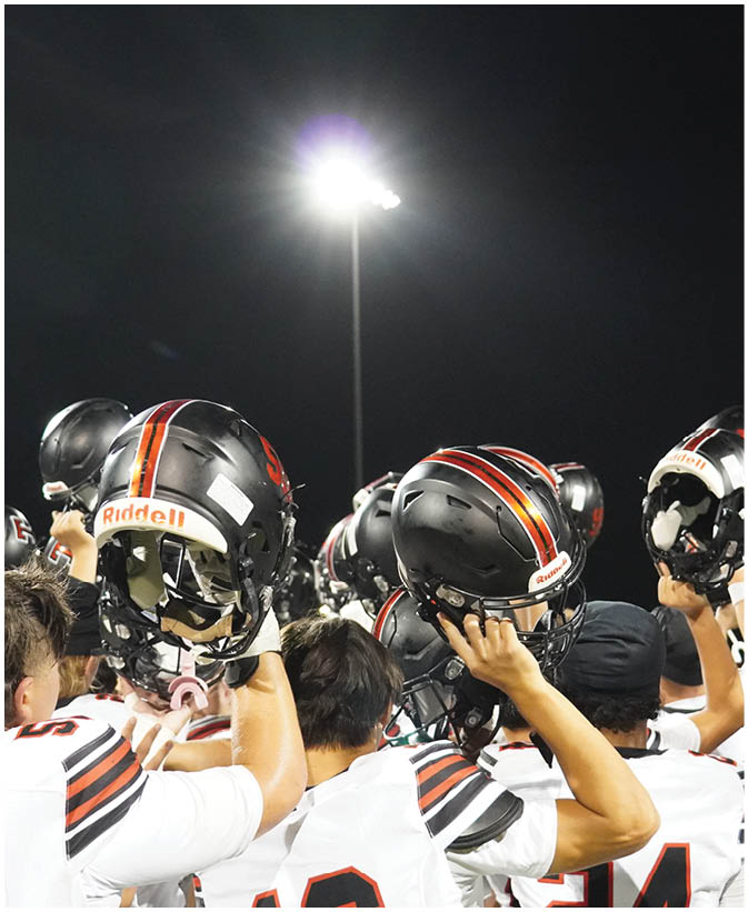 A group of football players on a field. Description generated by AI