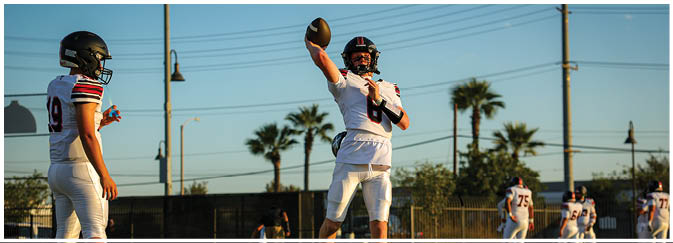 A football game is taking place on a field with players wearing blue and white uniforms. Description generated by AI
