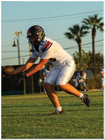 A football player wearing a blue and red jersey. Description generated by AI