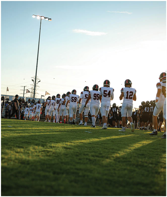 A group of football players on a field. Description generated by AI