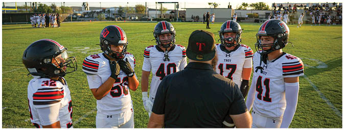 A group of football players on a field. Description generated by AI