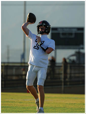 A football player wearing a blue and red jersey. Description generated by AI