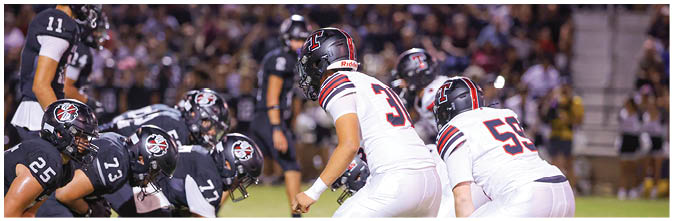 A group of football players on a field. Description generated by AI