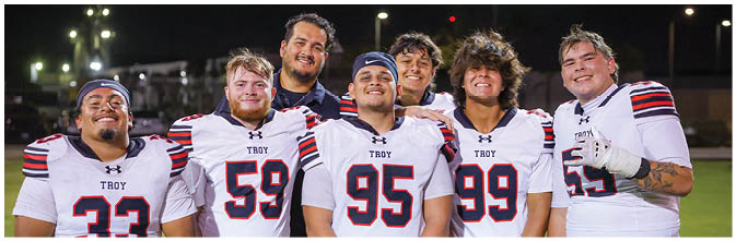 A group of football players on a field. Description generated by AI