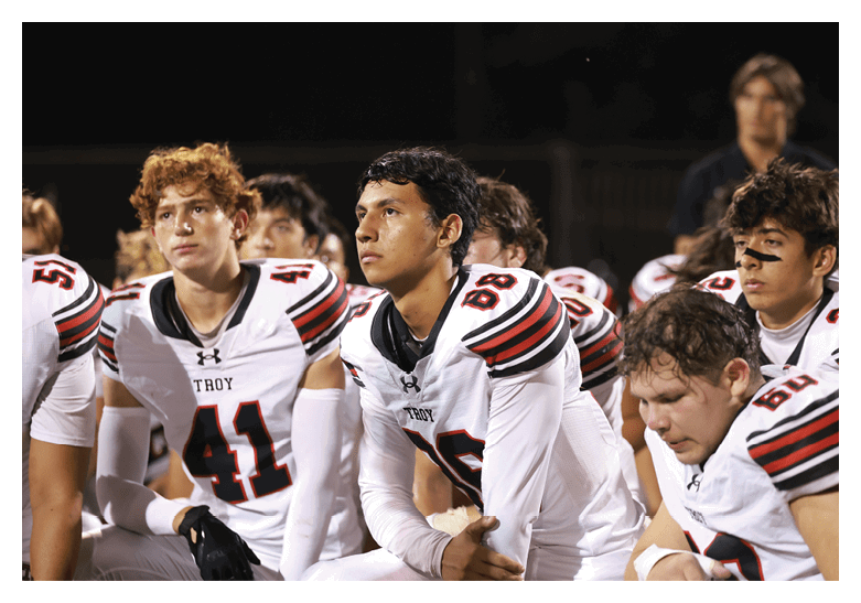 A group of football players on a field, one of them is running with a football. AI generated content