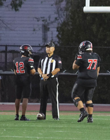 Two men embrace on a field, one wearing a black shirt and the other wearing a black and white shirt. AI generated content