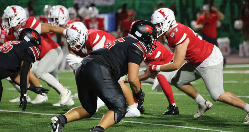 A group of people are kneeling on a field, possibly in a football game. AI generated content