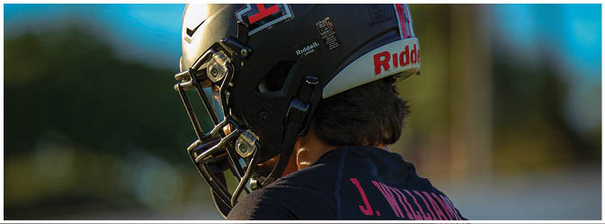 A football game is taking place on a field with players wearing blue and white uniforms. Description generated by AI