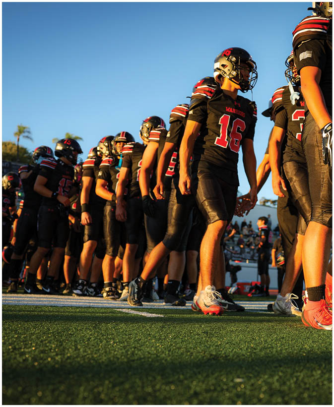 A group of football players on a field. Description generated by AI