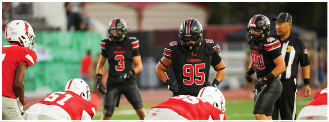 A football game is taking place on a field with players wearing blue and white uniforms. Description generated by AI