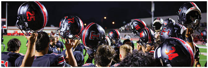 A group of football players on a field. Description generated by AI