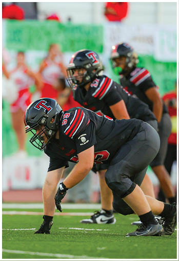 A group of football players celebrating a touchdown. Description generated by AI