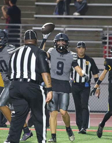 Two men embrace on a field, one wearing a black shirt and the other wearing a black and white shirt. AI generated content