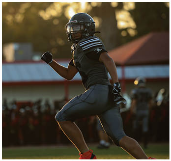 A football player running on the field. Description generated by AI