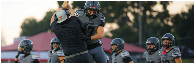 A group of football players on a field. Description generated by AI