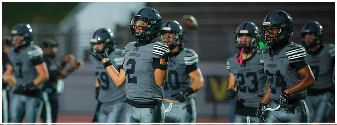 A football game is taking place on a field with players wearing blue and white uniforms. Description generated by AI