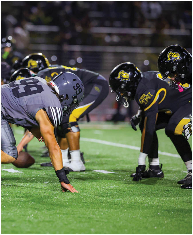 A group of football players on a field. Description generated by AI
