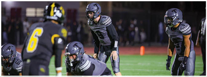 A football game is taking place on a field with players wearing blue and white uniforms. Description generated by AI