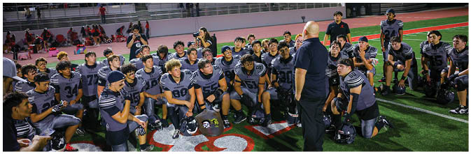A group of football players on a field. Description generated by AI