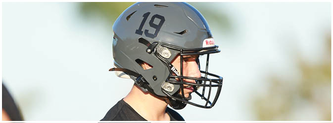 A football game is taking place on a field with players wearing blue and white uniforms. Description generated by AI